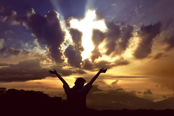 Silhouette of woman with cross on sky — Stock Photo, Image