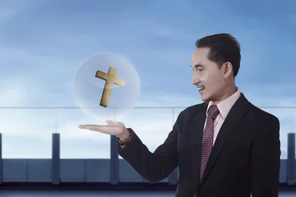 Businessman holding christian cross — Stock Photo, Image