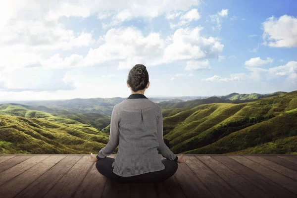 Kvinnan som gör meditation på trägolv — Stockfoto