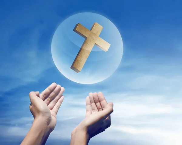 Mãos segurando cruz cristã na esfera — Fotografia de Stock