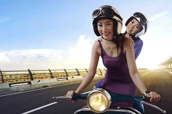 Азиатские женщины на винтажном скутере — стоковое фото