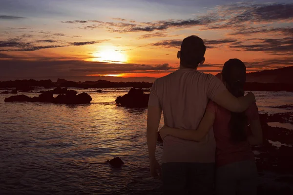 Paar genießt schönen Sonnenuntergang am Strand — Stockfoto