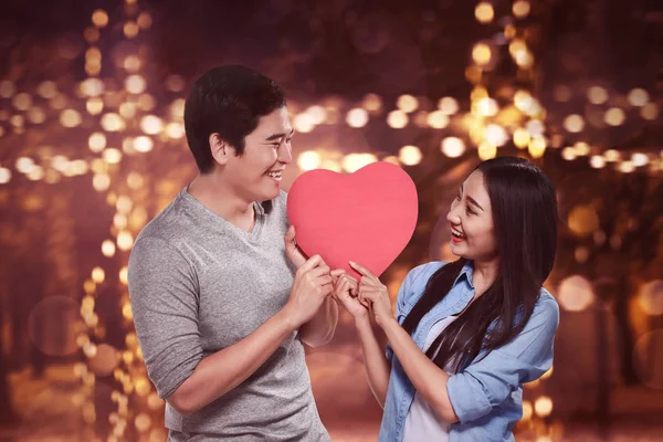 Asiático casal segurando forma do coração — Fotografia de Stock