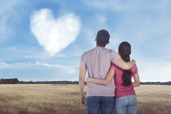 Couple looking on cloud with heart — Stock Photo, Image