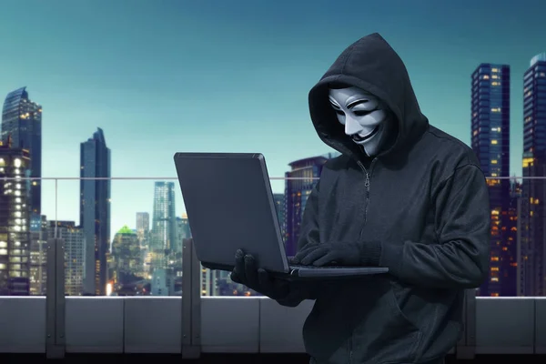 Hacker hält Laptop in der Hand — Stockfoto