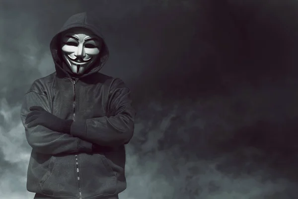 Porträt eines vermummten Hackers mit Maske und Handschuhen auf dunklem Hintergrund — Stockbild Hacker mit Maske und Handschuhen — Stockfoto