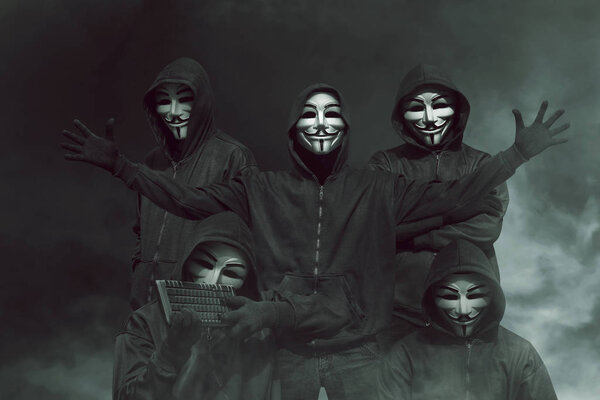 хакеры в масках с клавиатурой
