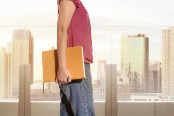 Mujer de pie y sosteniendo libro — Foto de Stock