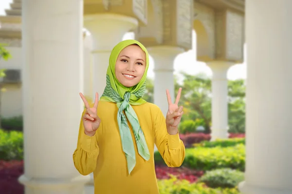 Азиатка мусульманка со знаками мира — стоковое фото