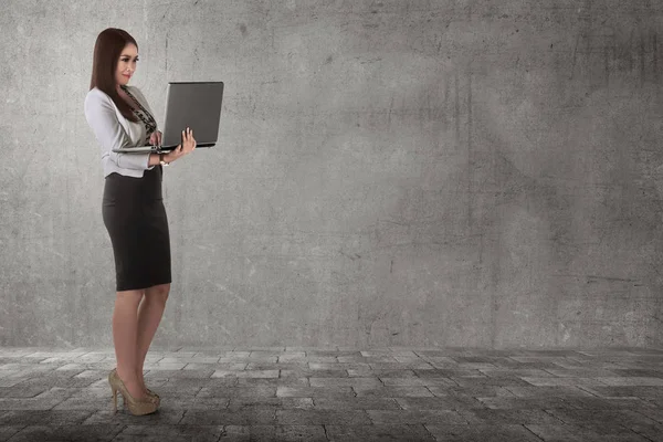 Усміхнена бізнес-леді стоїть з ноутбуком — стокове фото