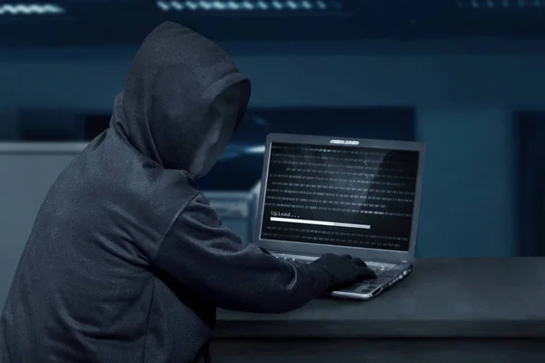 Hacker in mask typing on laptop — Stock Photo, Image