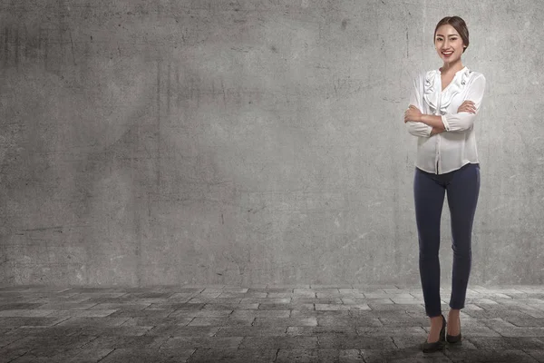 Smiling businesswoman standing with folded arms — Stock Photo, Image