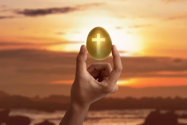 Altın yumurta şekilden ışık tutan el — Stok fotoğraf