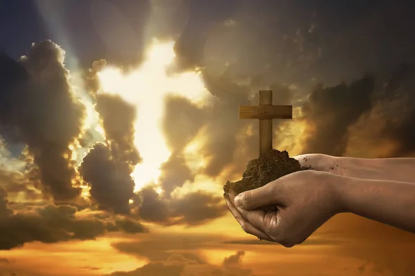 Menschliche Hand hält christliches Kreuz mit Erde an der Hand — Stockfoto