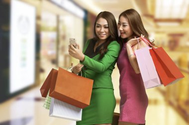 İki genç Asyalı kadınlar alışveriş torbaları ile