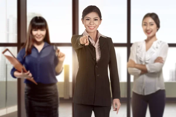 Atractiva mujer de negocios asiática con el equipo señalando con su dedo —  Fotos de Stock