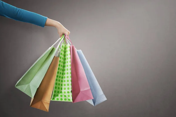 Pessoas mão segurando sacos de compras coloridos — Fotografia de Stock