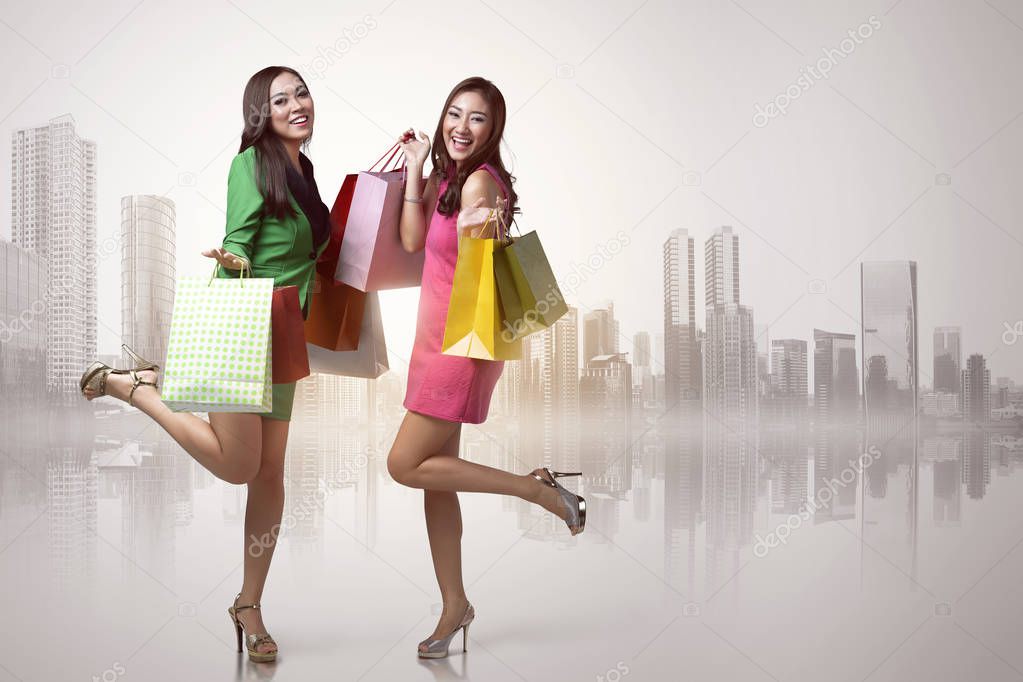 Two asian young women with shopping bags