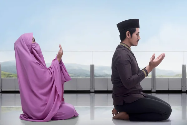 Muslim man and woman praying together — Stock Photo, Image