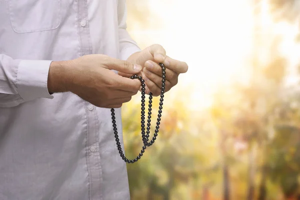Hands of muslim person with prayer beads — Stock Photo, Image