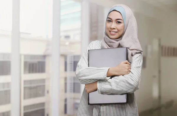 Aziatische Moslimvrouw bedrijf laptop — Stockfoto