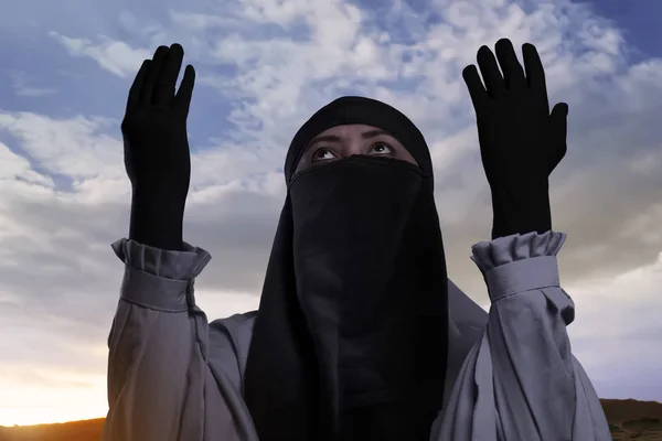 Frau mit Hijab hebt die Hand und betet — Stockfoto