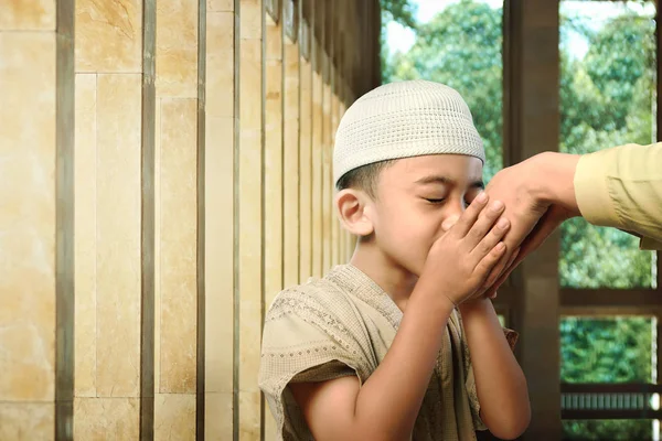 Muslim kid kissing parent hand — Stock Photo, Image