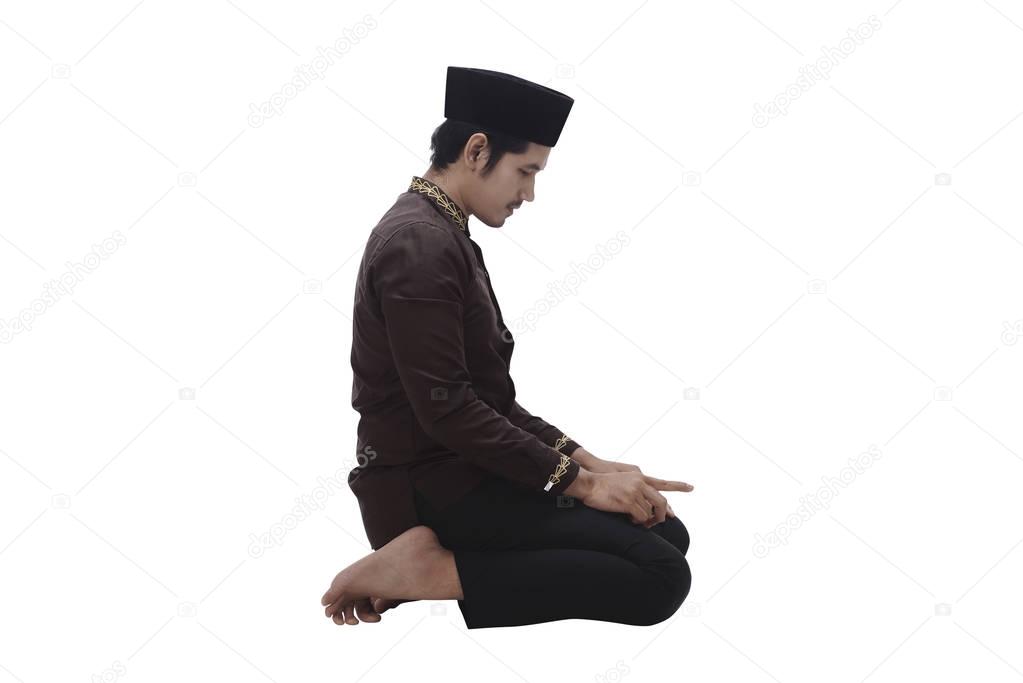 muslim man kneeling while praying