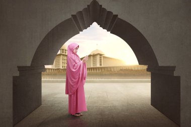 Güzel Asyalı Müslüman kadın yükselterek el peçe takıp dua