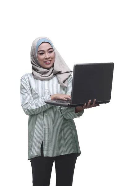 Hermosa mujer musulmana asiática sosteniendo mientras mecanografía en el portátil — Foto de Stock