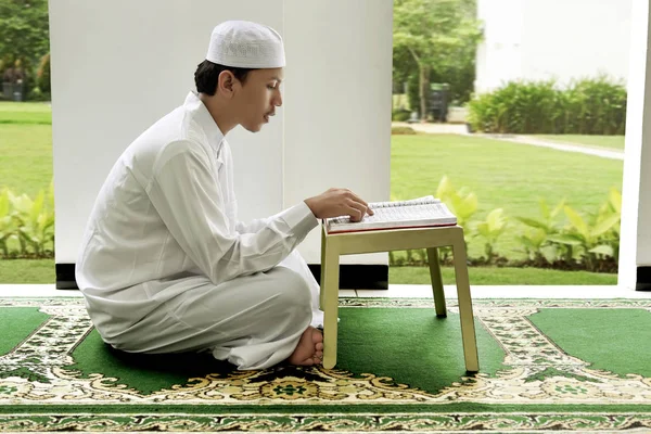 Widok boczny asian mężczyzna czytania świętych dokonać rezerwacji koran — Zdjęcie stockowe
