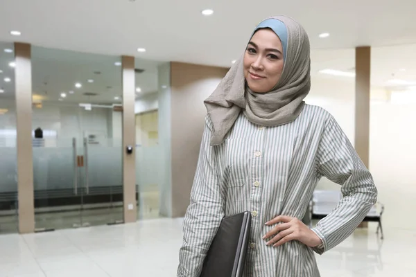 ラップトップを保持している腰に手で美しいアジアのイスラム教徒の女性 — ストック写真