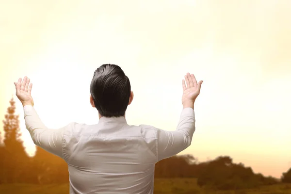 Rückseite eines asiatischen muslimischen Mannes, der die Hand hebt und betet — Stockfoto