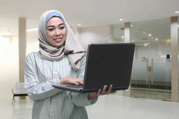 Joven asiático musulmán mujer usando laptop —  Fotos de Stock
