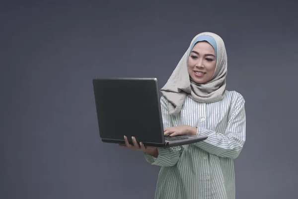 Retrato de mujer musulmana asiática con hiyab escribiendo en el portátil — Foto de Stock