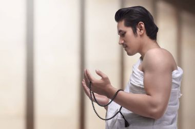 Portrait of asian muslim man with ihram praying to god clipart