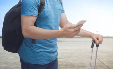 Adam holding cep telefonu ve bavul