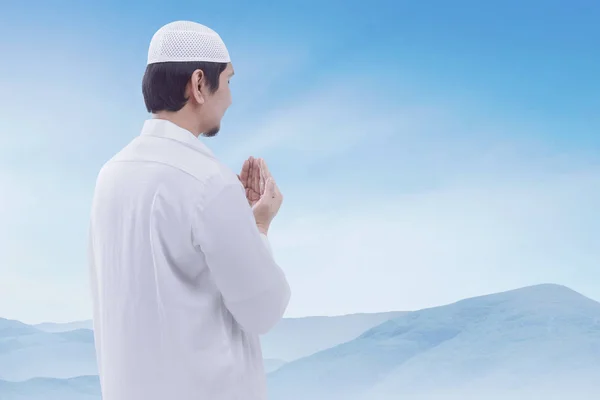 Young muslim man wearing cap praying — Stock Photo, Image