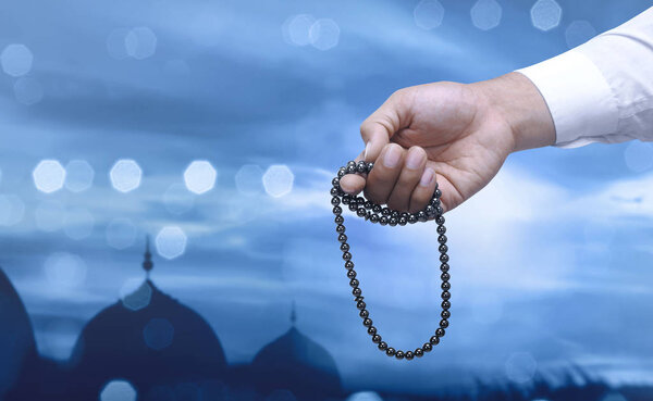 Muslim man praying with prayer beads