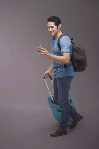 Άνδρας με σακίδιο χρησιμοποιώντας smartphone — Φωτογραφία Αρχείου