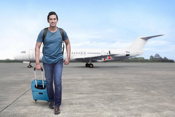 Traveler asiatiska man kliver av planet med resväska — Stockfoto