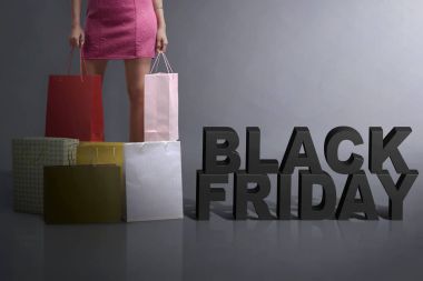 Genç müşteri alışveriş çantası ayakta Cuma Black ile tutarak te