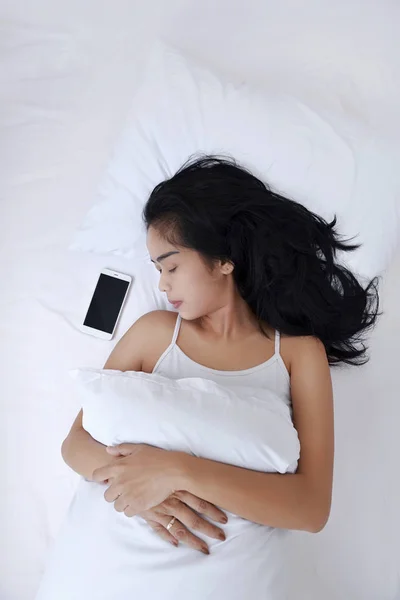 Азиатка спит с мобильным телефоном — стоковое фото