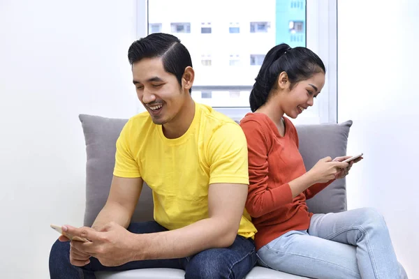 Asian pár ül a mobiltelefonok — Stock Fotó