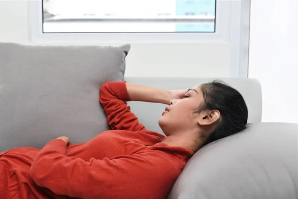 Asian woman sleeping on couch