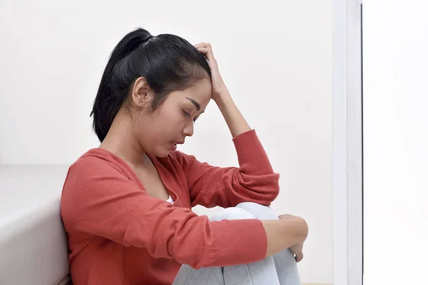 Aziatische vrouw knuffelen knieën — Stockfoto