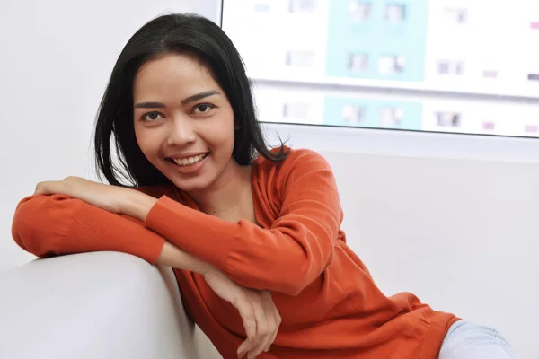 Asian woman sitting on couch — Stock Photo, Image