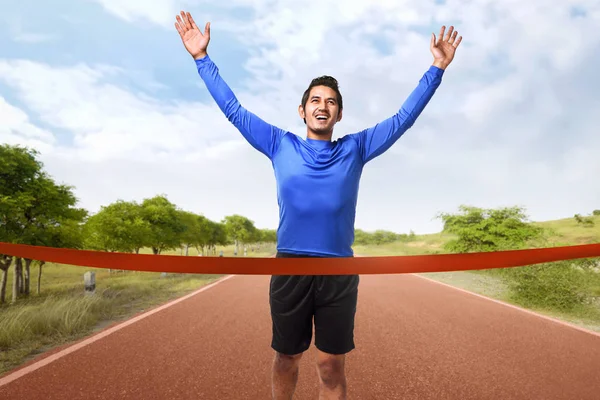 Asian man crossing finish line — Stock Photo, Image