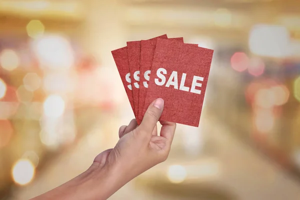 Ruka držící červenou kartu s textem prodej — Stock fotografie