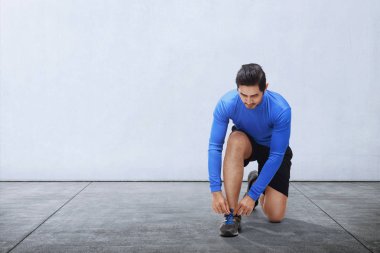 Genç Asyalı adam kravat spor ayakkabı bağcıklarımı 